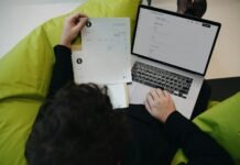 A person sitting on a bean bag chair working on a laptop