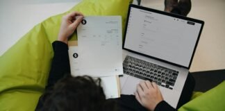 A person sitting on a bean bag chair working on a laptop