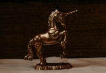 a golden statue of a unicorn on a white sheet