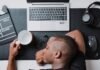 a man sitting at a desk with a laptop and headphones