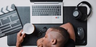 a man sitting at a desk with a laptop and headphones